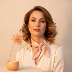 Portrait of Camille Laurent, a woman with a confident, elegant expression against a clean, cream background.